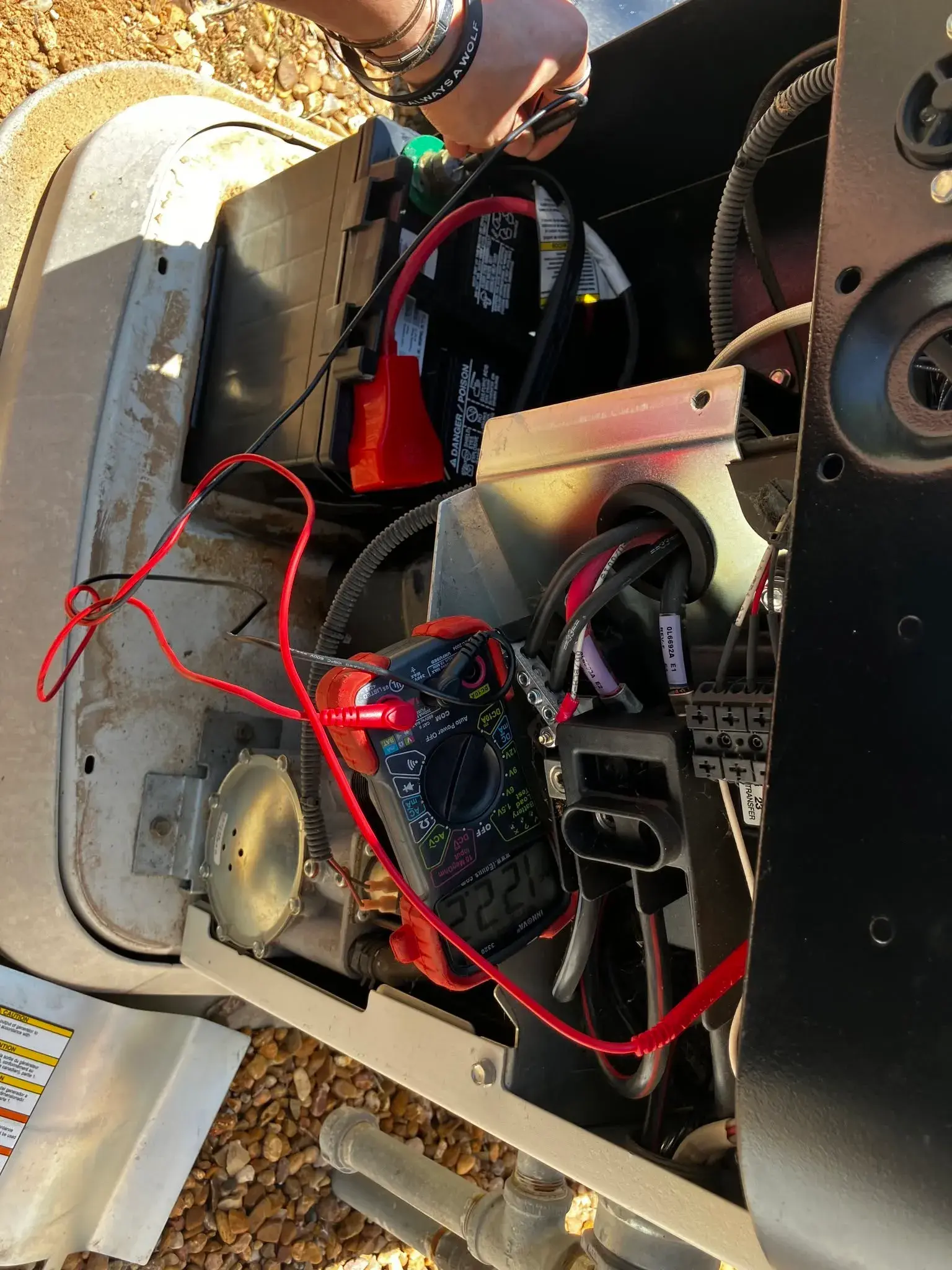 Technician metering a generator battery during a no-start diagnosis