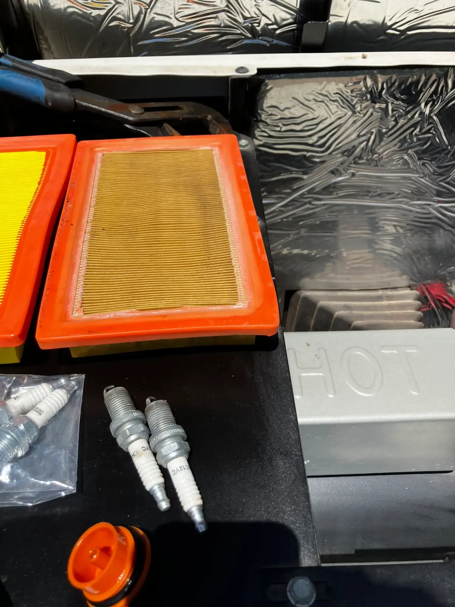 New air filters, spark plugs, and oil filter laid out during a generator tune-up