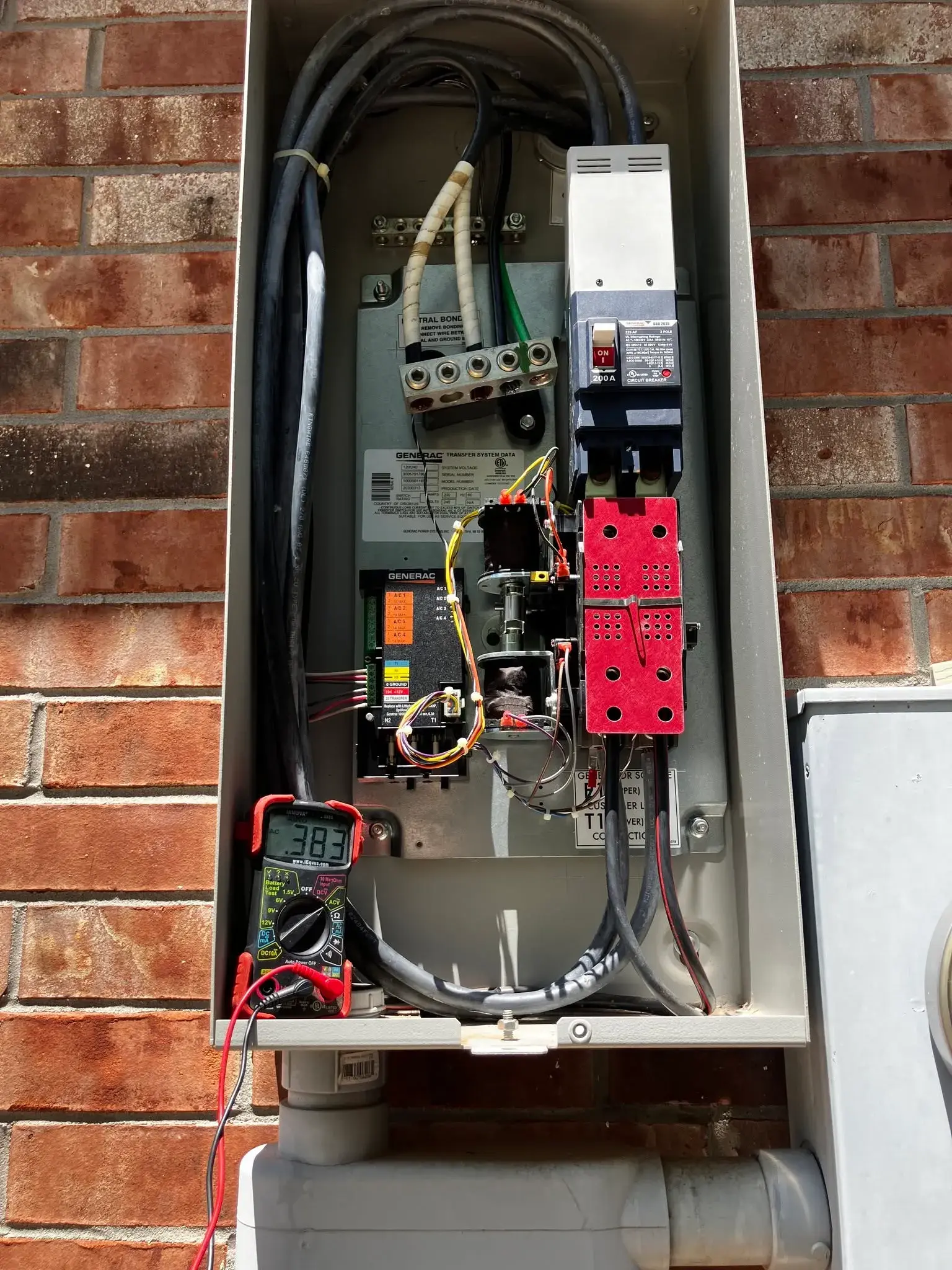Automatic transfer switch open with a multimeter testing the wiring
